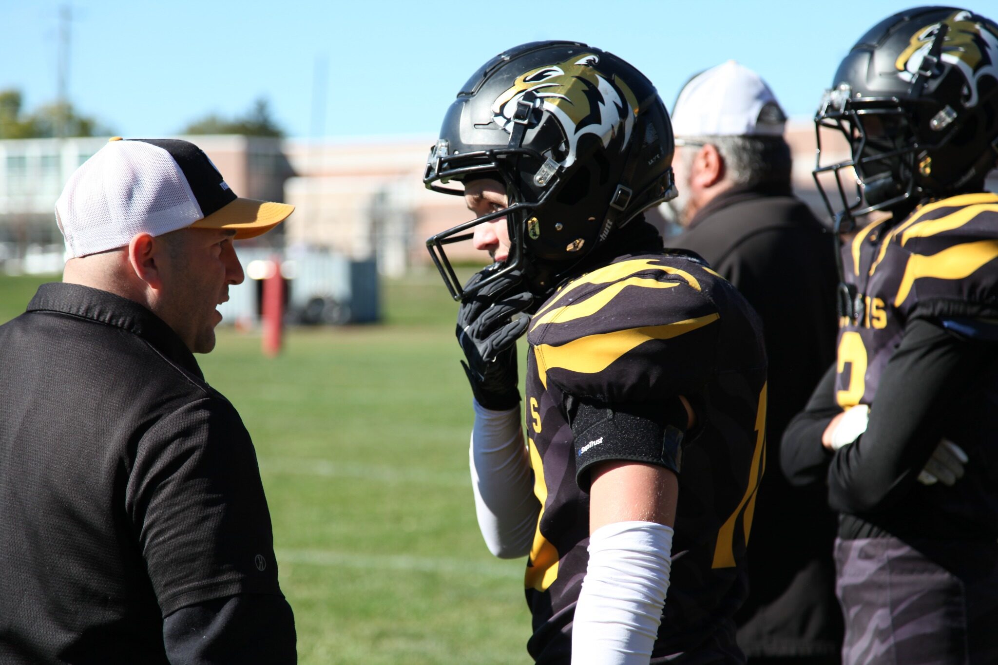 A Tigers coach speaks with players on the sideline