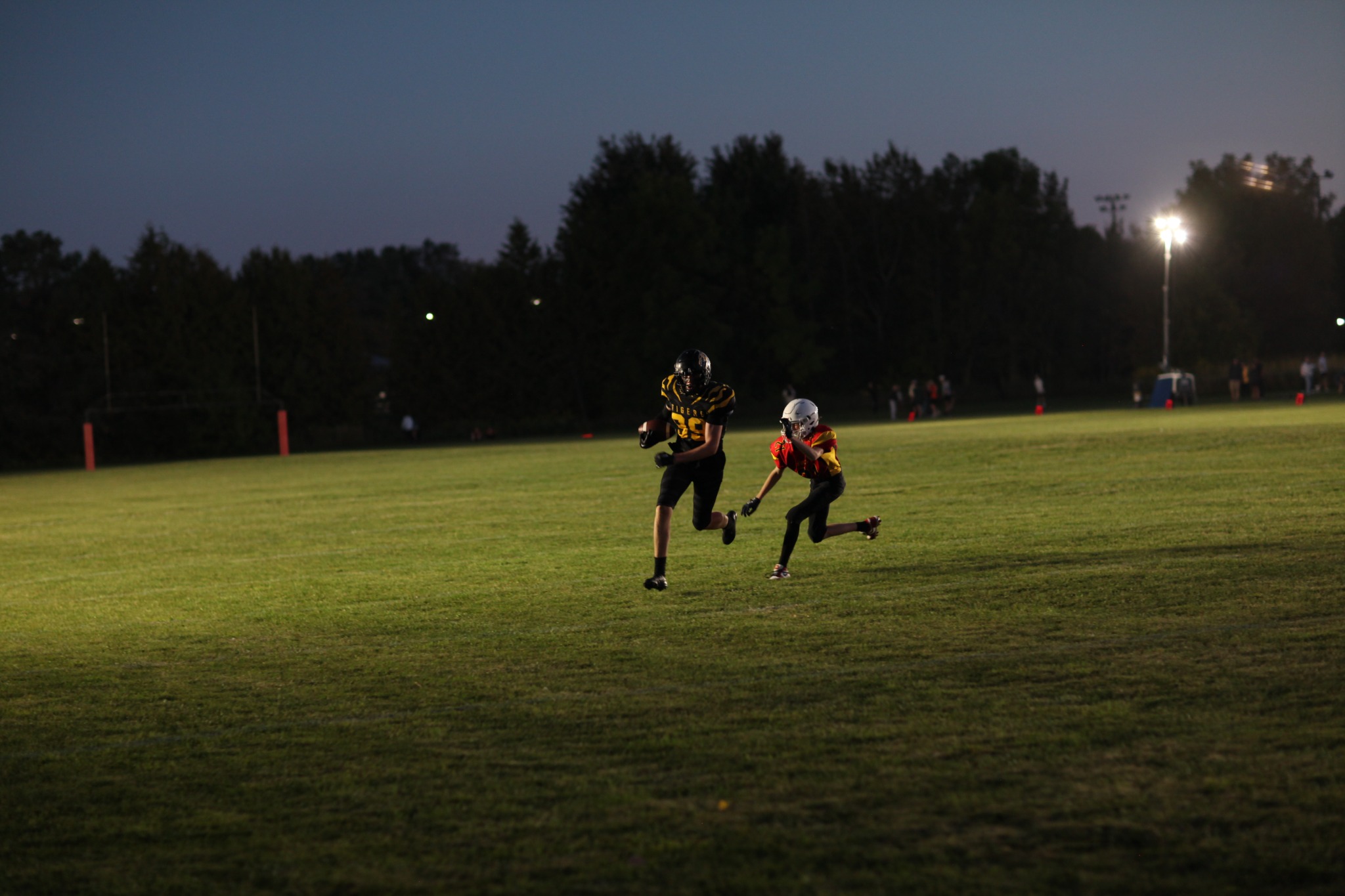 A Tigers player runs in the open field under the lights